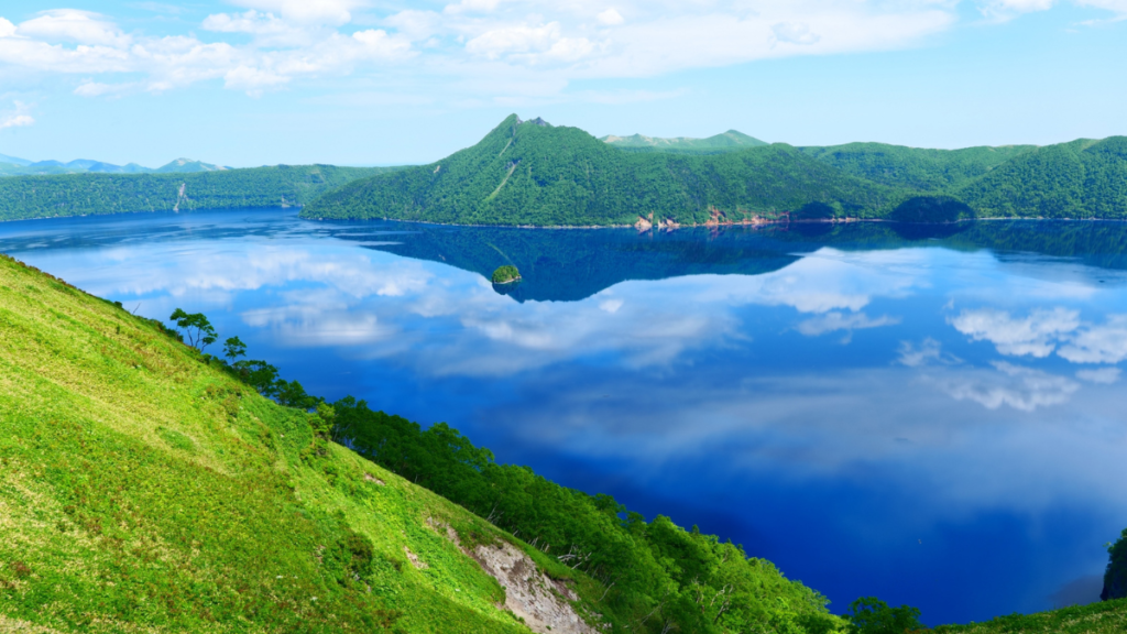 青い湖面に空と山並みが映る摩周湖