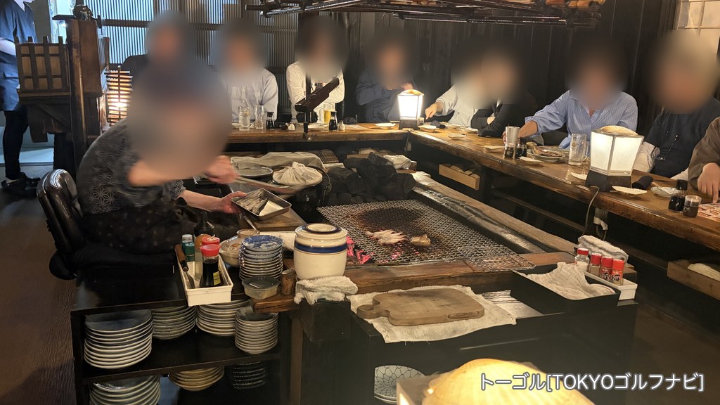 炉ばたの囲炉裏で魚を焼く様子
